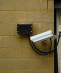 Beefy Black Plastic Waterproof Electrical Junction Box 115x90x55mm With Mounting Ears installed outdoors on yellow brick wall