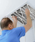 Man installing Air Bear 20 x 25 x 5 Inch MERV 8 High Performance Air Purifier Filter Replacement in ceiling vent