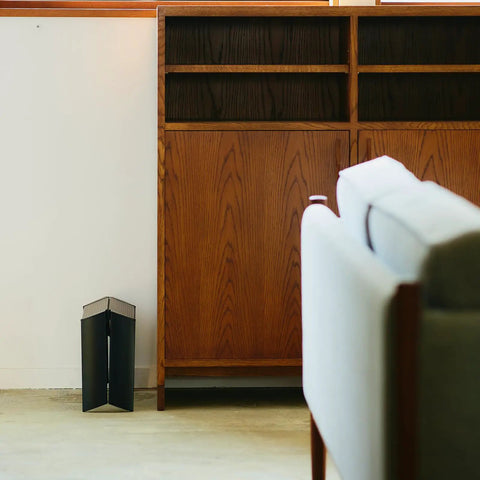 Ml10 1BK 1 Step Ladder Black With Folding Safety Bar self-standing when folded beside wooden cabinet in living room