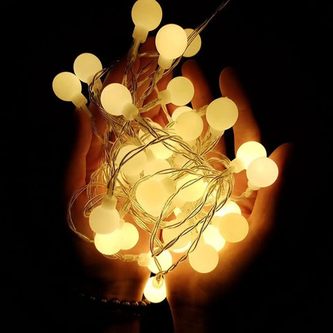 Battery Operated Globe String Lights 33ft With 100 LED Globes Remote Control 8 Modes And Timer Warm White Cozy Vibes glowing in hands
