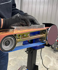 Hella Compatible 2X48 Belt Grinder Attachment Converts Standard Bench Grinder Into Rock Solid Vertical Or Horizontal Grinding Rig Featuring No Sweat Quick Change Tension System in use with sparks.