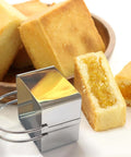 Square stainless steel biscuit cutter with attached ring handle; pastry and cookie shaping tool.