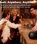 Group of people enjoying music at a bar with a pocket-sized Bluetooth speaker on a counter, showing 5W stereo sound, IP7 waterproof
