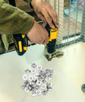Built Tough Chicago Style Binding Screws For Books And Scrapbooks And Paper Crafts Using 75 Piece Silver Carbon Steel Fasteners with a drill and screws on a workspace.