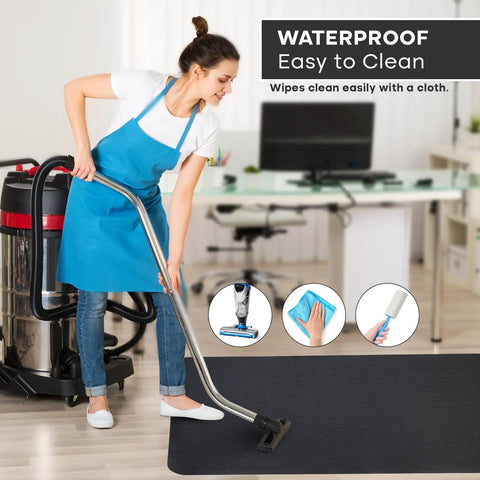 Woman cleaning large black chair mat in office, demonstrating waterproof surface of Massive 53x45 Inch Chair Mat for Hardwood and Tile Floors