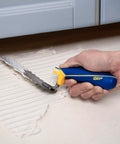 Person using Comfort Grip Square-Notch Margin Tile Trowel With Six-Inch By Two-Inch Blade for thinset application under cabinet.