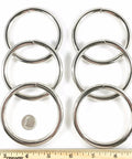 Front view of six nickel-plated steel O-rings, 2.5 in inner diameter, arranged on white background.