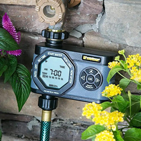Hydrologic 4 Zone Digital Water Timer With Smart Zone Control, mounted on a water spigot among garden plants