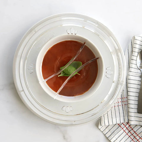 Top view of 10 Inch Plate Cover Dome Shield for mess free cooking, covering a white plate with soup, on a marble surface.