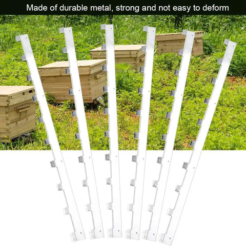 6 Pack Metal Beehive Frame Spacers For Solid Hive Framing Rugged Beekeeping Frame Strips in front of wooden hives