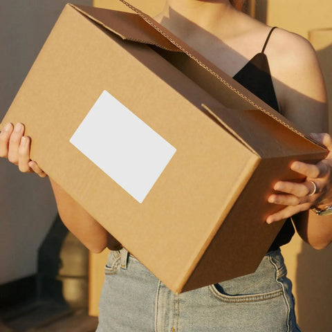 Person holding a box with 160 Sheets White Synthetic Paper Shipping Labels With Super Sticky Adhesion And Ample Writing Space