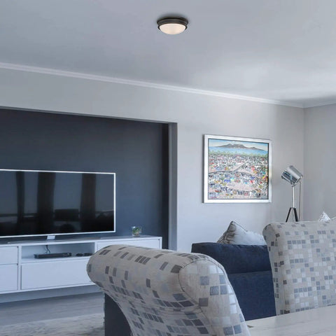 Living room with Two Light Indoor Flush Mount Ceiling Fixture in Oil Rubbed Bronze with Frosted Glass and Highlight Detailing Classic Vibe Style 13 Inch Ceiling Light For Living Rooms And Hallways, illuminating the space.