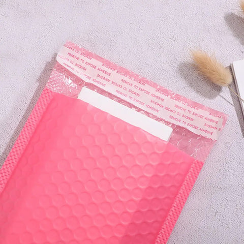 Pink Bubble Mailer Envelopes 11x15 Plus 4 Inch Padding Self Sealing Shipping Bags Thick, Shockproof Bubble Pouches on table