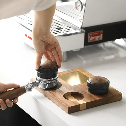 58mm Espresso Coffee Distributor Leveler With Stepless Height Adjustment placed on portafilter next to espresso machine