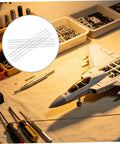 Workbench with model aircraft, surrounded by tools and 10 Pcs Carbon Fiber Rods 2mm Diameter And 500mm Length For RC Planes and Drones.