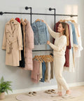 Heavy Duty Industrial Pipe Clothing Rack With Four Hanging Rods Wall Mounted Garment Rack Black Steel Frame with coats and denim.
