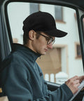 Man wearing Lightweight Adjustable Cotton Dad Hat for Men with Relaxed Fit, sitting in vehicle reading paper