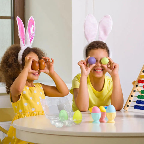 Children wearing bunny ears playing with colorful eggs and 36 pack clear plastic egg cartons with six egg capacity on table.