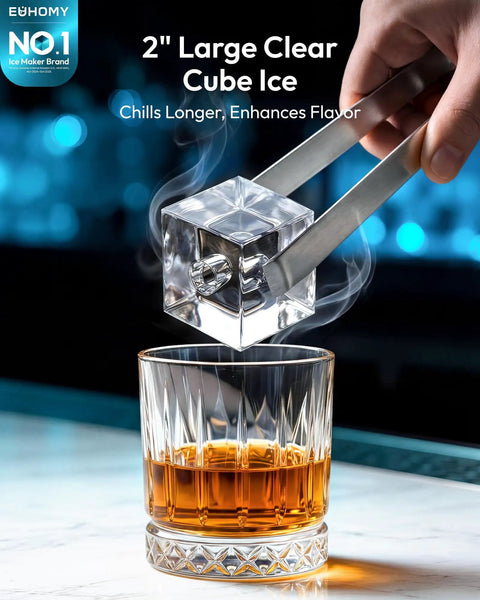 Hand using tongs to place 2" large clear cube ice into a whiskey glass, showcasing Top Counter Ice Cube Maker App Enabled Produces 110 Massive Two Inch Crystal Clear Daily Cubes For Your Home Bar With Lightning Fast Freeze And Killer Cool Vibes You Really Gonna Love.