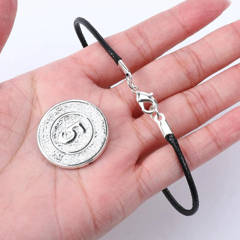 Hand holding bracelet with 3MM ID cord end cap and lobster clasp from 20 sets stainless steel necklace clasps and end caps for jewelry making.