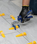 Using Tile Leveling Pliers Kit For Lash And Xtreme Pro Systems with adjustable head and wedges on floor tiles.