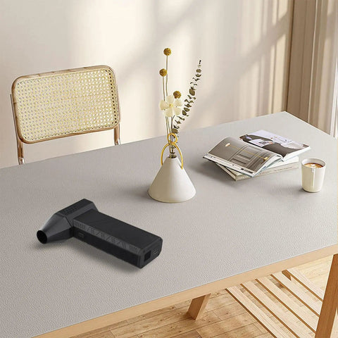 Professional Cordless Air Blower With 180 Watt Brushless Motor Delivering 130000 RPM on a table, ideal for dust cleanup and pet drying.