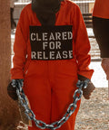 Person in orange costume wearing 2 Pack Plastic Halloween Fake Prison Chains With Handcuffs And Footcuffs For Realistic Prisoner Look