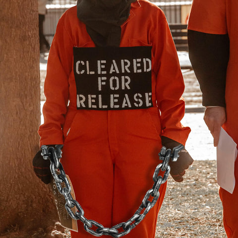 Person in orange costume wearing 2 Pack Plastic Halloween Fake Prison Chains With Handcuffs And Footcuffs For Realistic Prisoner Look