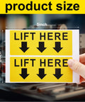Two bright yellow lift here label decals, 5x2 in, black text with downward arrows.