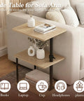 Built Tough 360 Degree Swivel C Shaped End Table With Roomy Three Tier Open Storage Rack And Heavy Duty Metal Frame Featuring Slick Oak Finish For Couch Or Bedside beside a sofa with books and a vase.