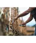 Person using Elite Pruning Shears For Serious Gardeners 7.7 Inch Swiss Made Bypass Pruner With Leather Wrapped Handle to cut branches.