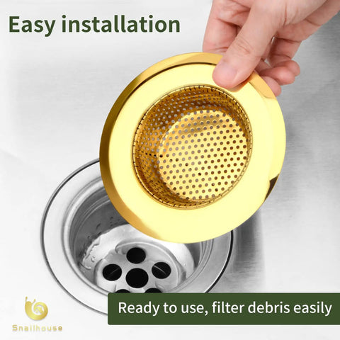 Two Pack Stainless Steel Kitchen Sink Strainers With Gold Finish, 4.5 Inch Wide Rim being fitted into sink drain.