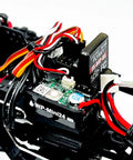 Close-up of the electronic components in Built Different 1/18 Scale Brushless Rc Truck Crawler Rtr with colored wires and circuit board.
