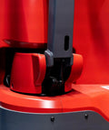 Close-up of the base of the Heavy Duty Fully Electric Adjustable Straddle Stacker, showing red and gray components.