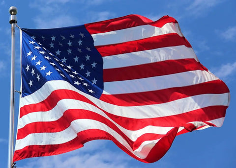 The American flag waving against a clear blue sky