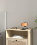 Tree Of Aura Smart Bedside Lamp With Wireless Charging on a nightstand next to a bed and books in a cozy bedroom setting
