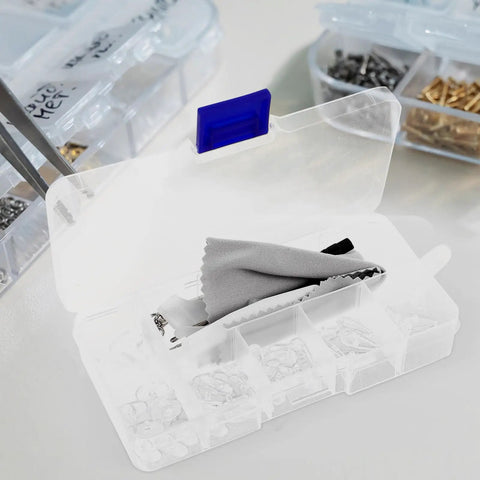 Open eyeglass repair kit with precision tools, screws, and cleaning cloth for glasses and sunglasses maintenance.