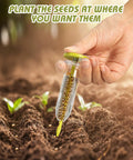 Hand using 17 Pack Seed Planter Tool Hand Seeder Mini Sowing Seed Dispenser in garden soil with sprouts