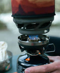 MiniMo Camping And Backpacking Stove Cooking System in use showing FluxRing Technology and adjustable heat control outdoors.