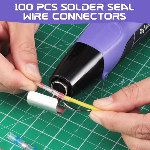 Using 100Pcs Heat Shrink Solder Seal Wire Connectors with heat gun on green cutting mat for wiring repair.