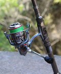 Close-up of a metallic reel and handle on a Telescopic Fishing Rod For Travel And Bass And Trout Angling With 24T Carbon Fiber Construction CNC Machined Reel Seat And Comfortable EVA Handle Silver 1.8m 5.9ft Portable Pole Saltwater Resistant Ceramic Ring Guides For Smooth Casting
