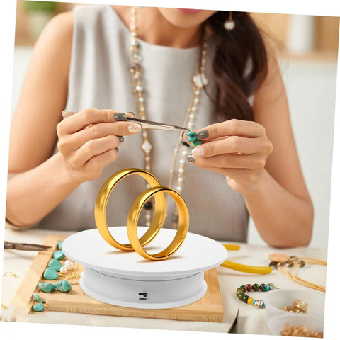Autonomic Electric Rotating Display Stand For Jewelry Watches And Collectibles With Adjustable Speed showcases gold rings and jewelry crafting.