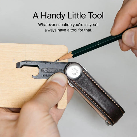 Ultra Slim Stainless Steel Multi Tool V2 With Titanium Coating Pocket EDC Gear for package cutting on wooden surface.