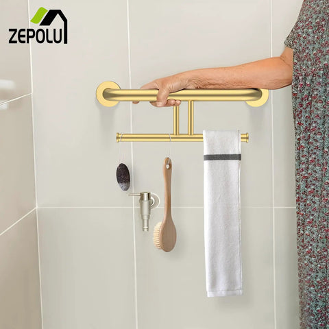 Heavy Duty Brushed Gold Handicap Grab Bar With Integrated Toilet Paper Roll Holder And 304 Stainless Steel Build Offer Kick Ass Grip And Drip Worthy Wall Mounted Bath Safety Rail For Real Ones Who Want Solid Support held by hand in a bathroom.