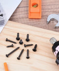 Over Four Hundred Piece Stainless Steel Black Wood Screws Set With Phillips Pan Head Self Tapping Coarse Thread scattered on wood