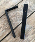 Heavy Duty Wall Mounted L Shape Shelf Brackets Two Pack Slick Black Finish Rust Proof Steel for pantry or deck on wooden surface.