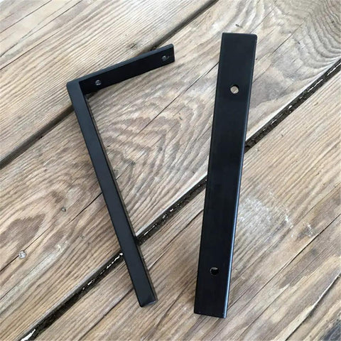 Heavy Duty Wall Mounted L Shape Shelf Brackets Two Pack Slick Black Finish Rust Proof Steel for pantry or deck on wooden surface.