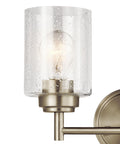 Close-up of Winslow 12.75-Inch Vanity Light in Brushed Nickel with clear seeded glass shade, bulb visible inside, wall-mounted