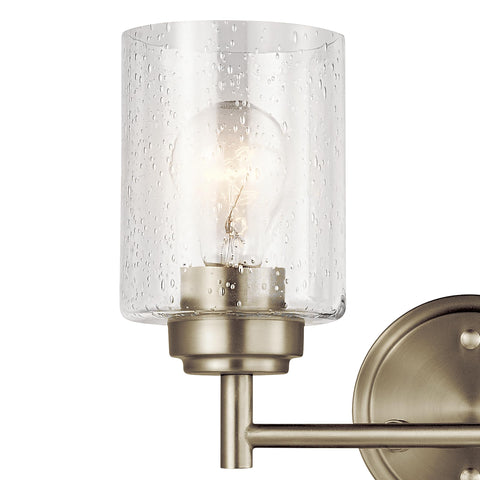 Close-up of Winslow 12.75-Inch Vanity Light in Brushed Nickel with clear seeded glass shade, bulb visible inside, wall-mounted
