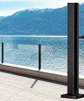 Legit Outdoor Deck Glass Balustrade Post with a sleek black finish overlooking a lake, made of 304 stainless steel, heavy duty.